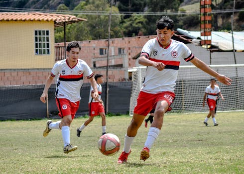 Youth soccer players in action during a sunny day match.