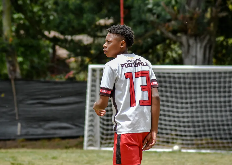 Jeune joueur de dos, maillot floqué du nom du club et du numéro 13