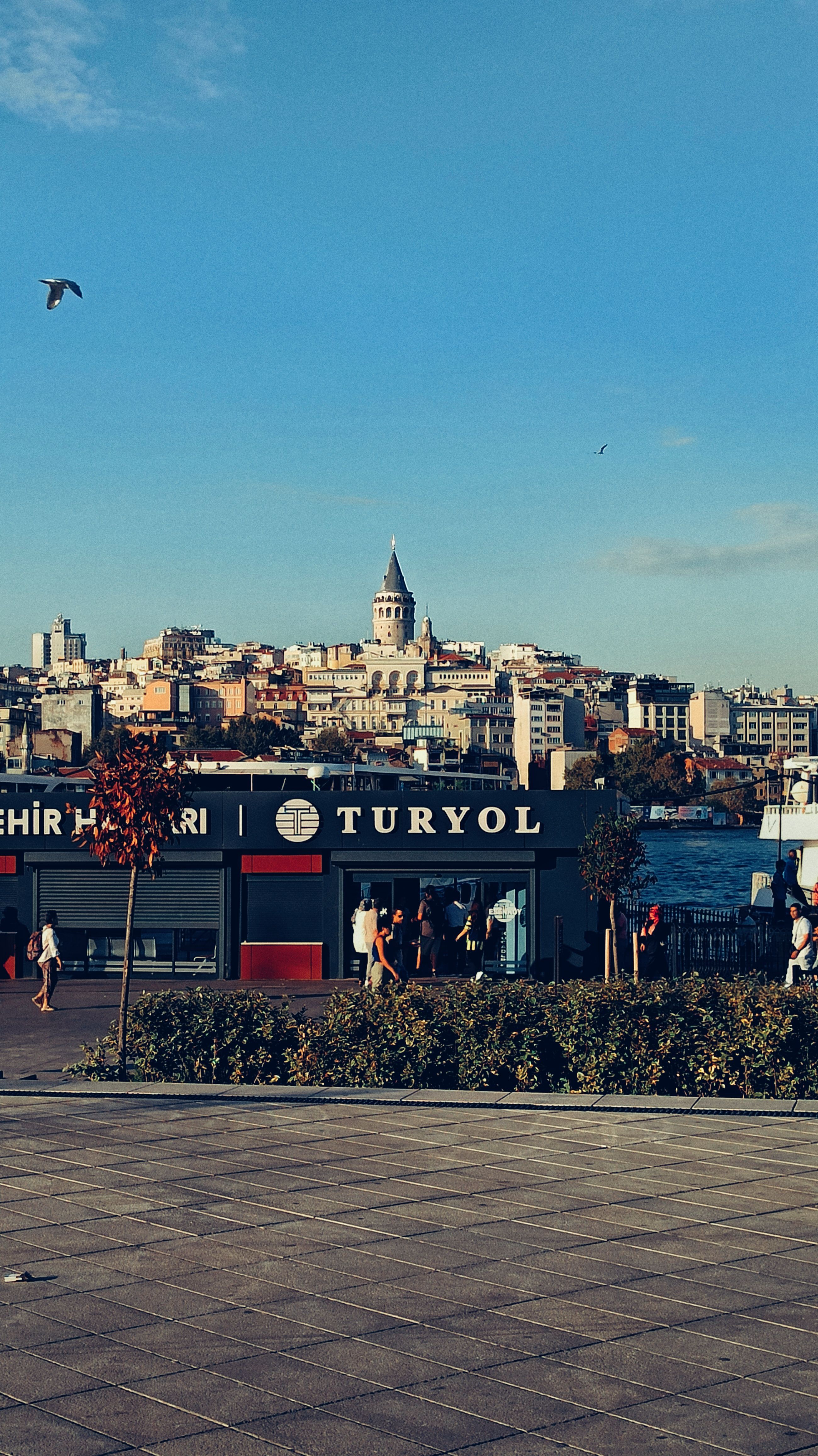 View of Galata Tower and Turyol ferry terminal in Istanbul with a clear blue sky