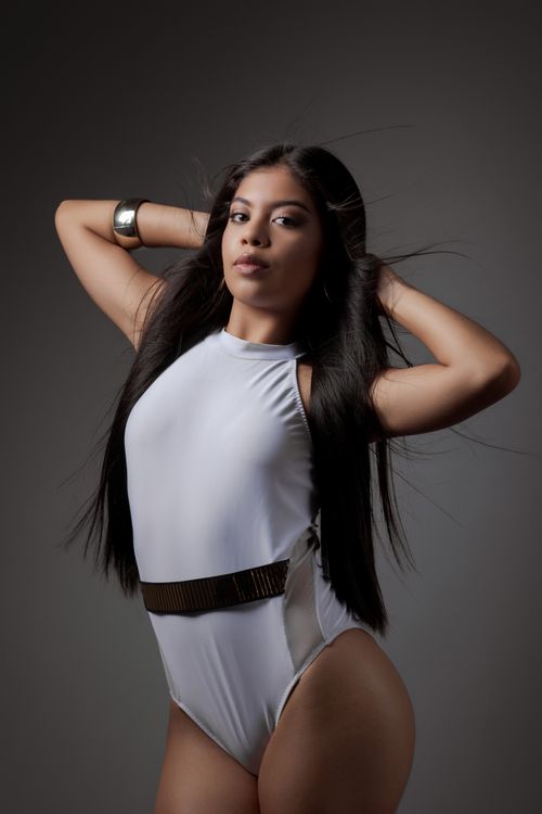Free Fashionable woman in a white outfit posing confidently in a studio setting. Stock Photo