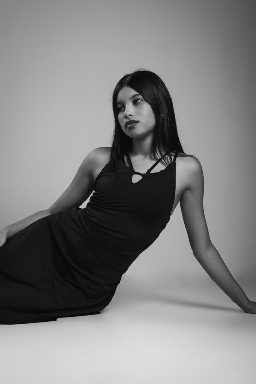 Free Elegant black and white portrait of a young woman in a relaxed pose, exuding confidence. Stock Photo