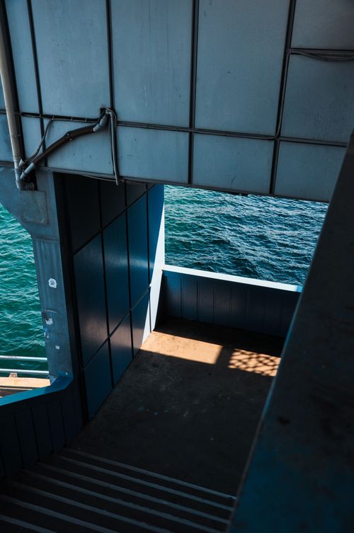 Free A modern industrial metal stairway with a view of the ocean, showcasing architectural design. Stock Photo