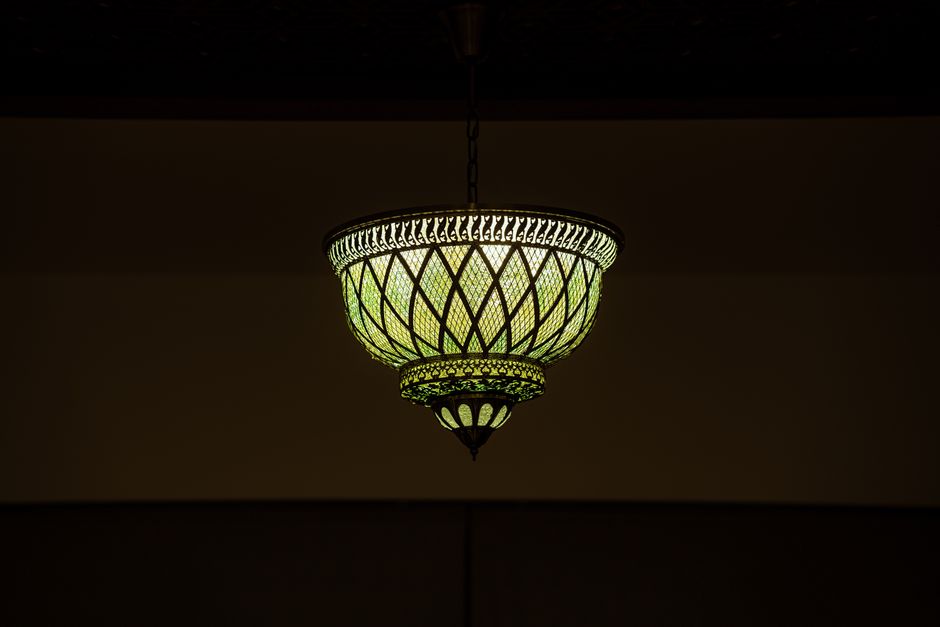Elegant vintage ceiling light fixture illuminating a dimly lit room with a warm glow.