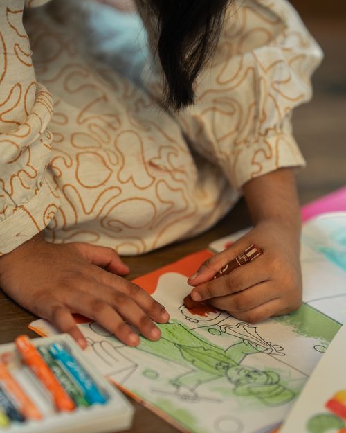 Free A close-up of a child drawing with crayons, showcasing creativity and childhood imagination. Stock Photo