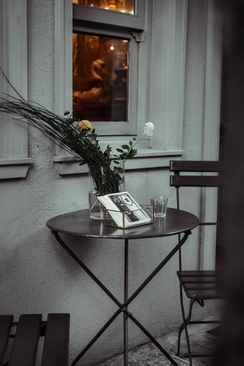Free Charming outdoor café table with flowers and photo frame against a wall, Istanbul. Stock Photo