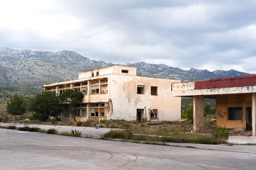 Free An old, abandoned building in a mountainous region with cloudy skies. Stock Photo