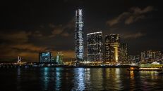 香港的夜间景观照亮天际线，展示了海滨的现代摩天大楼