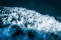 一个特写镜头捕捉了戏剧性的海浪，白色泡沫飞溅，展现出强烈的动感与能量