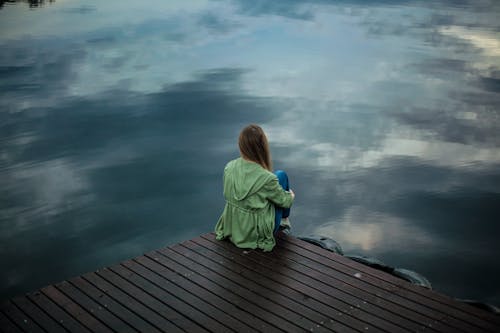 Free Woman Sitting on Wooden Planks Stock Photo