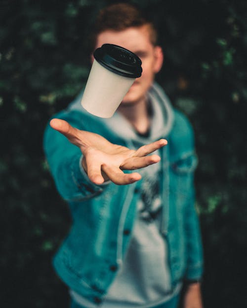 Free Shallow Focus Photo of Person Throwing White Plastic Cup Stock Photo