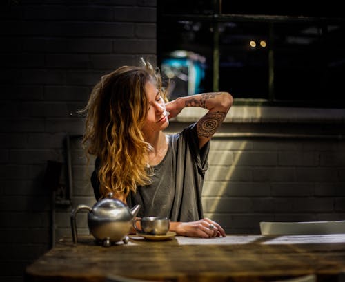 Free Woman Sitting Beside Table Stock Photo