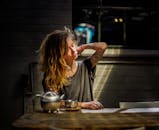 阳光明媚的房间里，一名纹身女子正喝茶放松身心，享受着随意而宁静的时刻