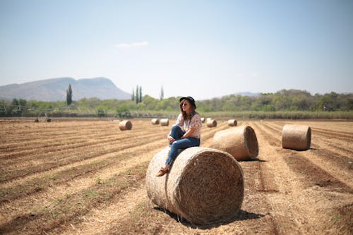 Woman Sitting on Hay Bale