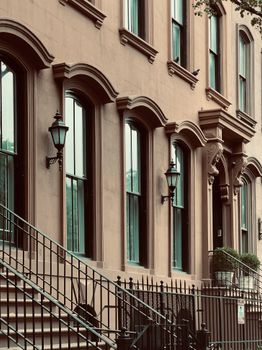 Classic brownstone building facade with ornate windows and iron staircase.