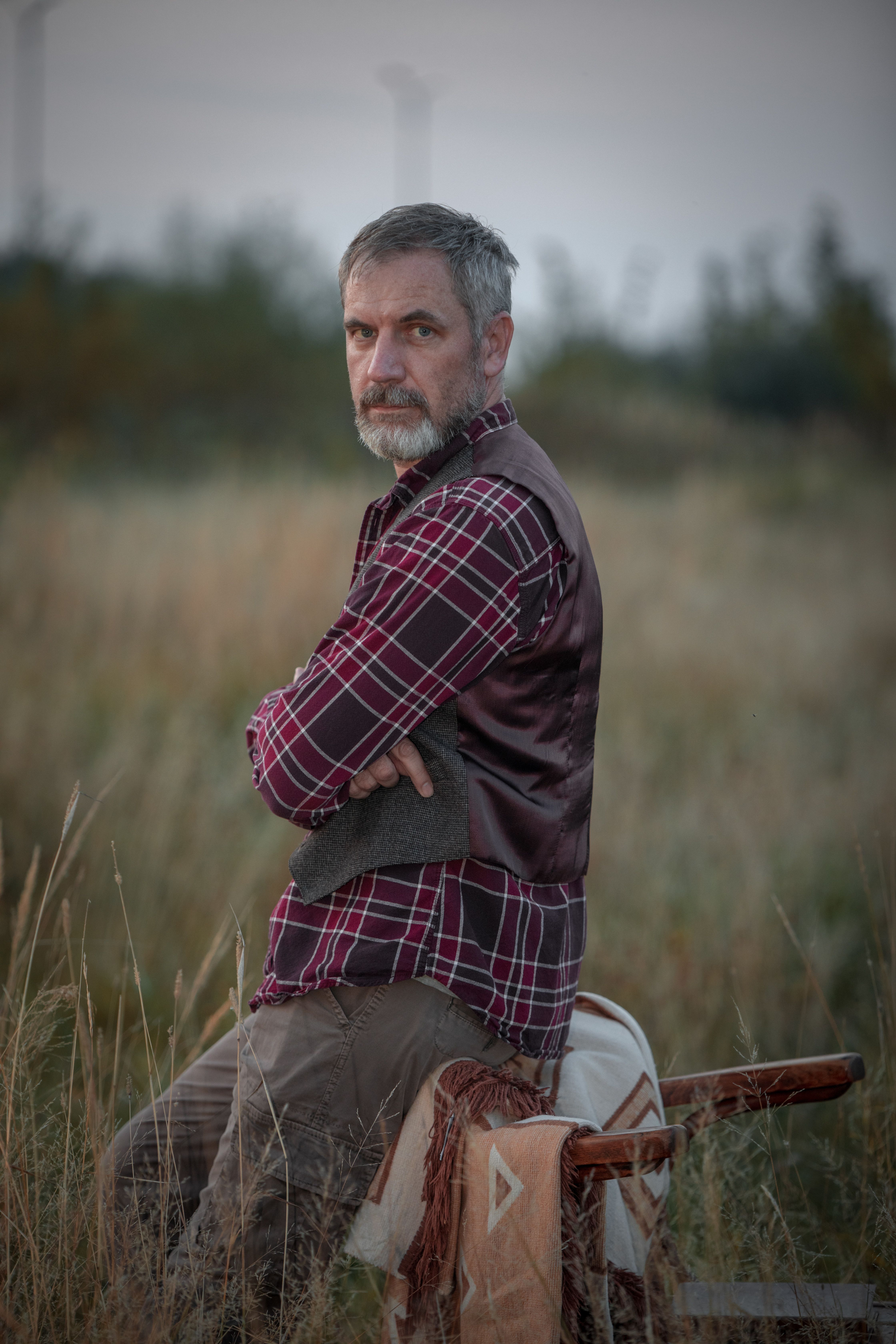 Mature Man in Plaid Shirt in Rustic Field Setting · Free Stock Photo