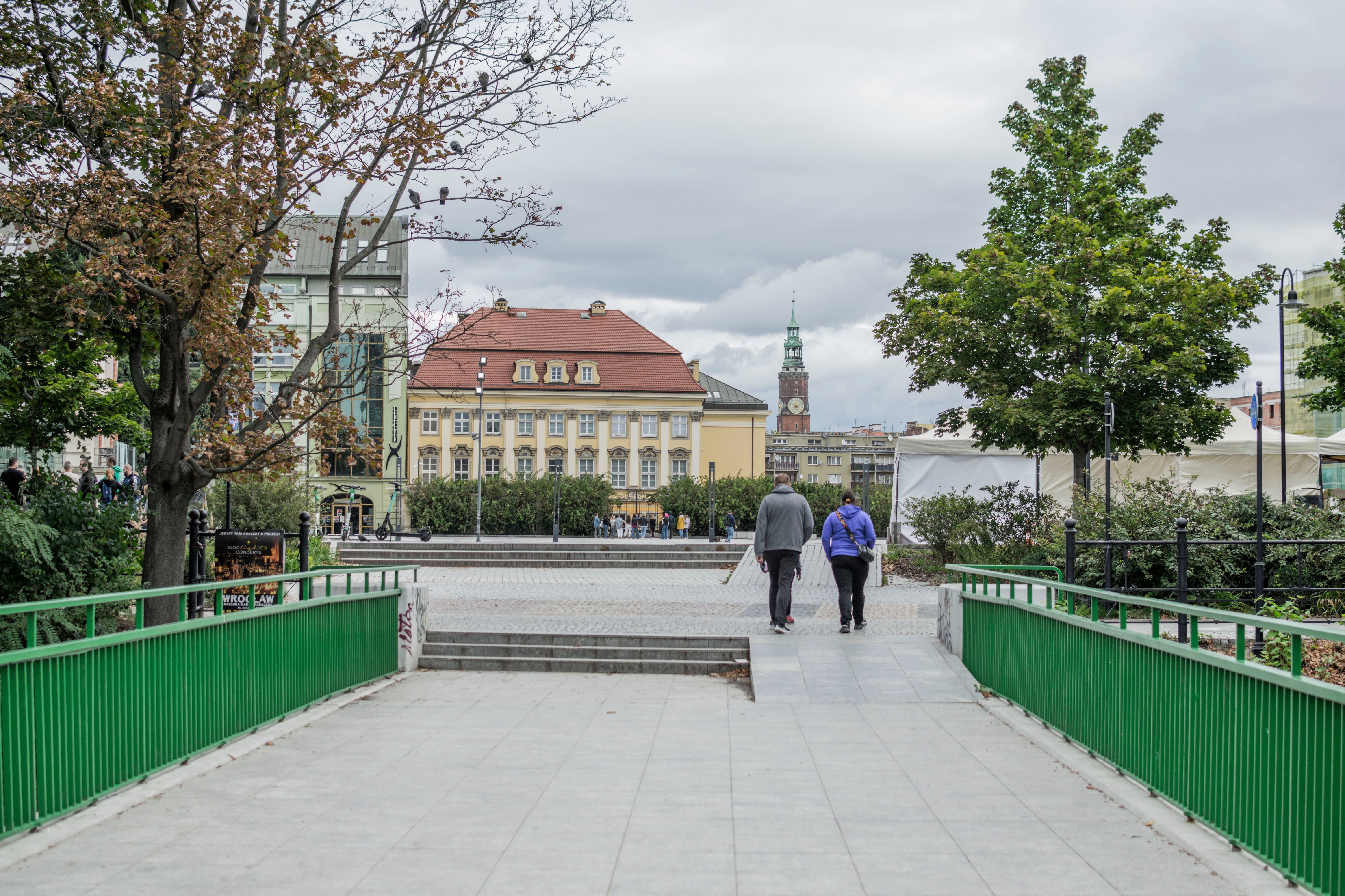 Explore the charming streets of Wrocław, featuring historic buildings and a peaceful pedestrian walkway.