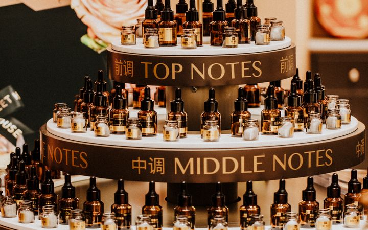 Luxurious perfume display with top, middle, and base notes bottles indoors.
