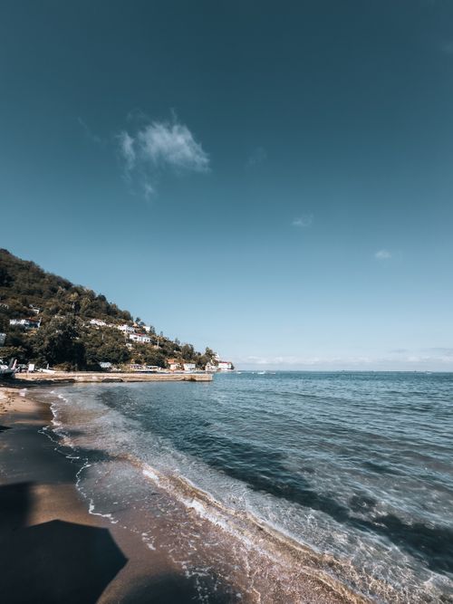 Free Breathtaking coastal scene with calm waves and clear sky, perfect for travel and nature themes. Stock Photo