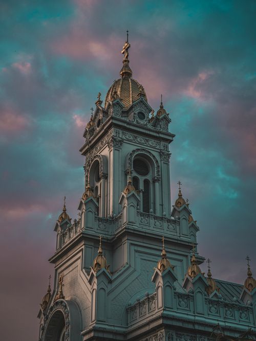 Free Stunning view of a church tower with intricate details under a dramatic sky during twilight. Stock Photo