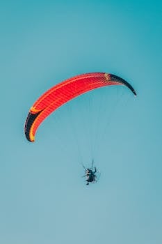 Experience the thrill of paramotoring against a stunning blue sky in Bashkortostan.