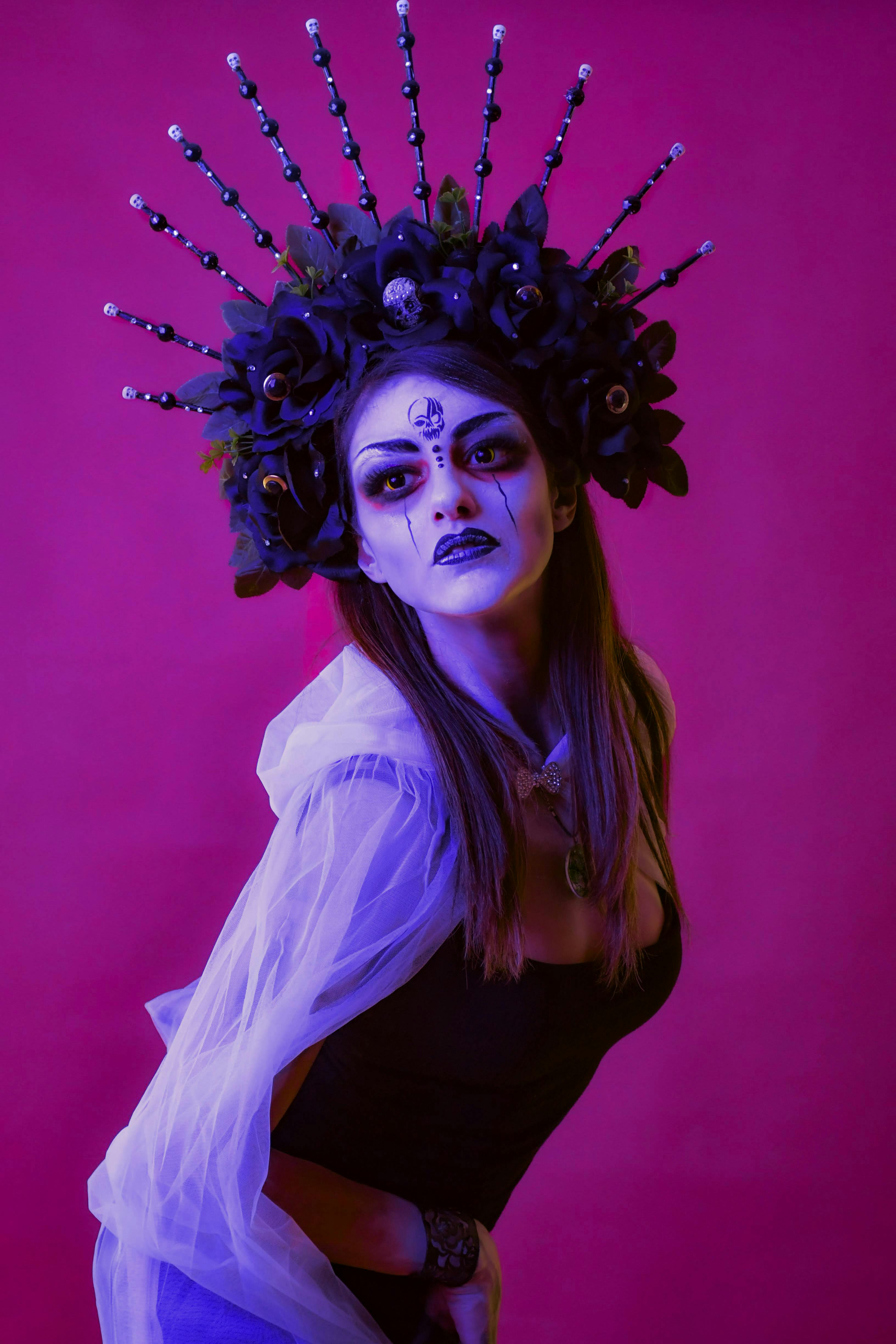 [ColoSach]-a-striking-portrait-of-a-woman-in-dramatic-makeup-and-headpiece-against-a-purple-backdrop.