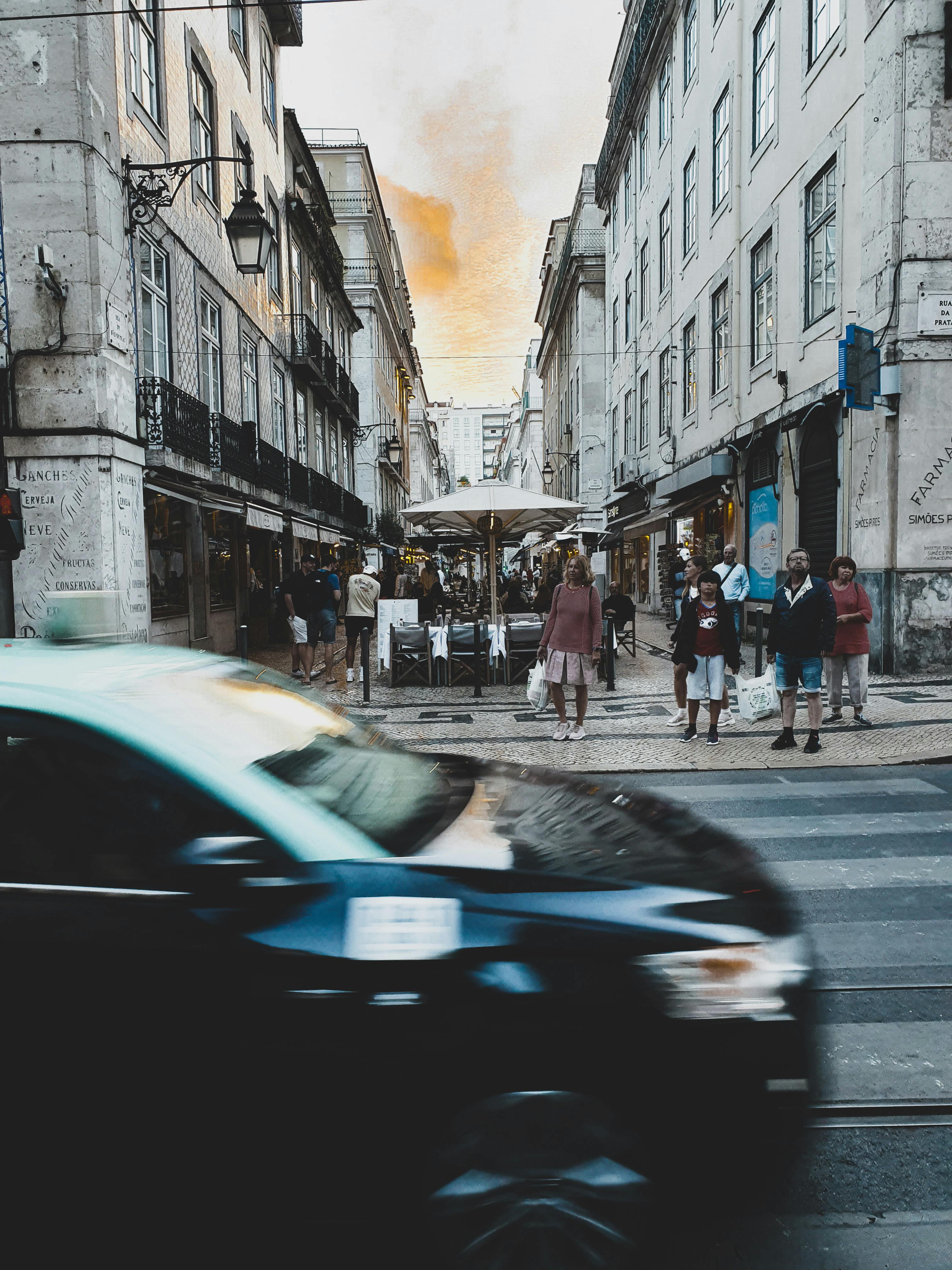 城市环境中，街景充满活力，周围有人，汽车行驶模糊