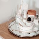 将美容产品时尚地排列在带有镜盘的木桌上，营造出美观的展示效果