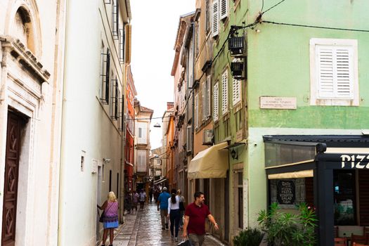 Picturesque European street with colorful buildings and pedestrians in a quaint town.
