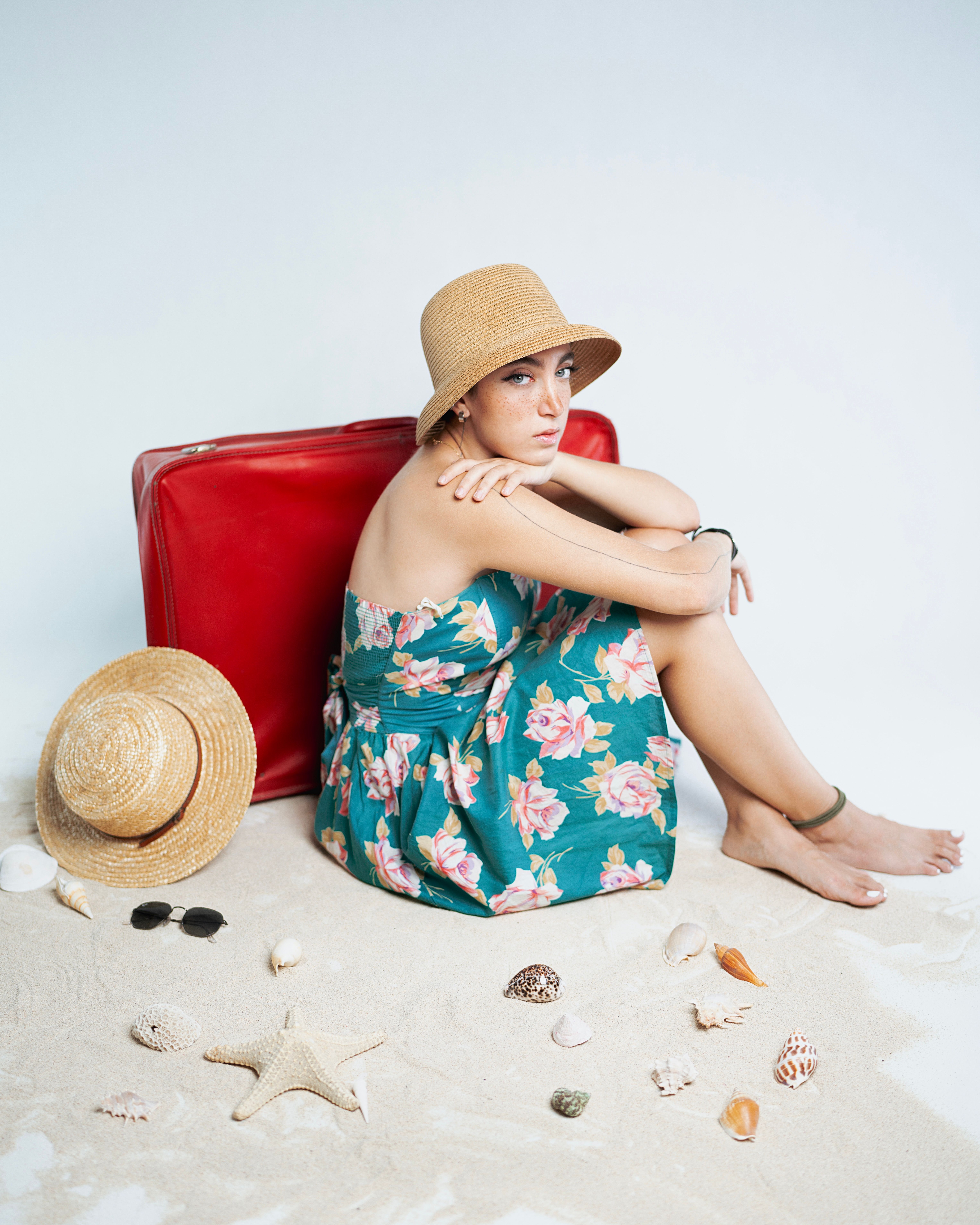 femme-l-gante-sur-la-plage-avec-une-valise-rouge-photo-gratuite