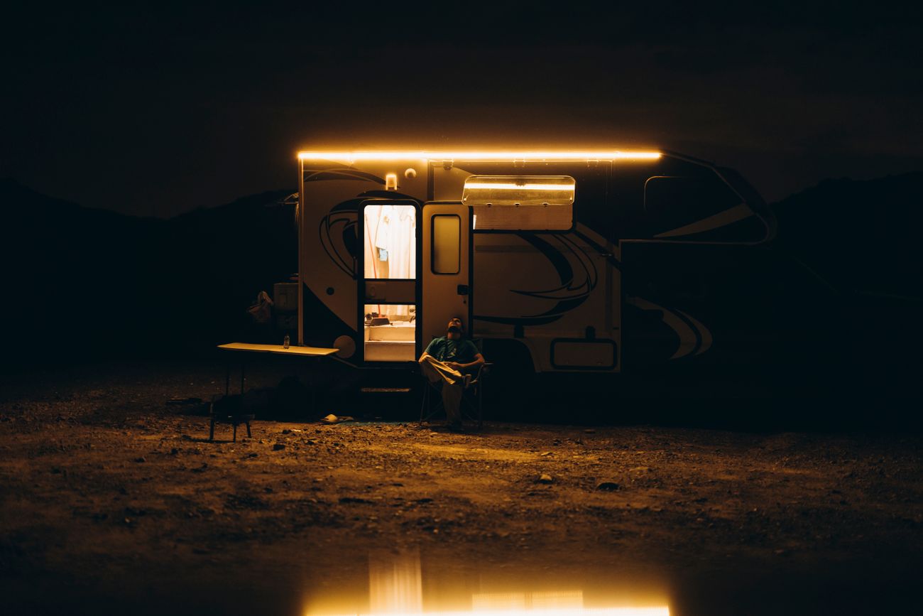 Vesper travel trailer lit from within on a desert plain after dark — photo by Eslam Mohammed Abdelmaksoud on Pexels