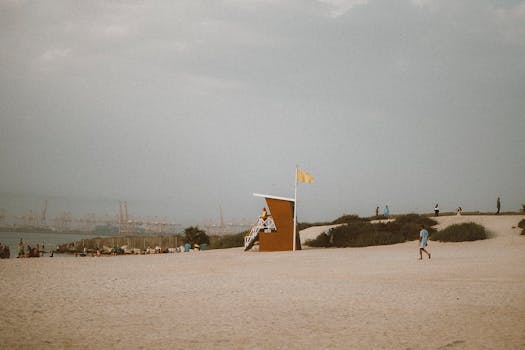 A peaceful beach scene at Jebel Ali with lifeguard hut and people enjoying the day.