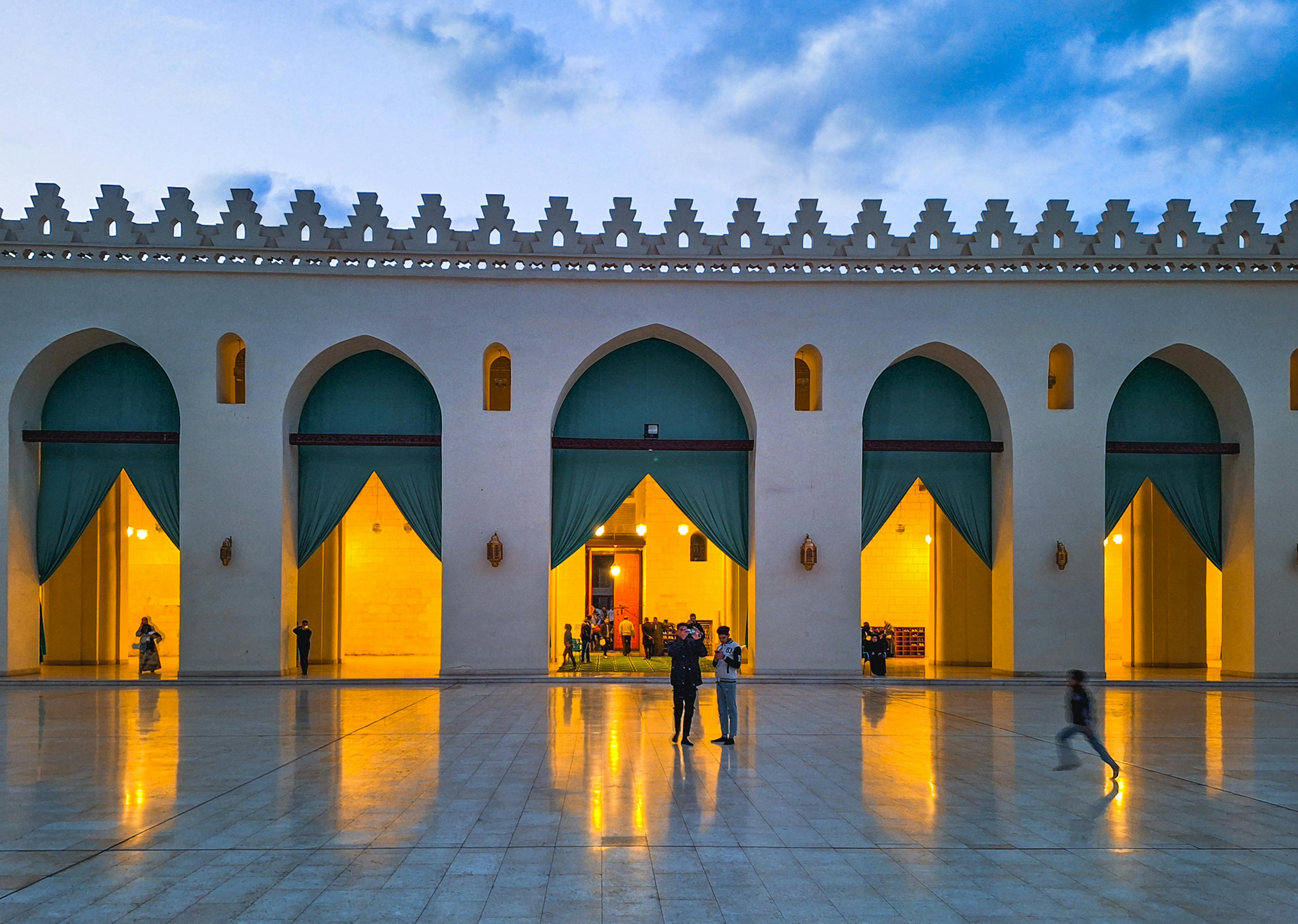 Beautiful illuminated view of Al-Hakim Mosque during twilight in Cairo, showcasing Islamic architecture.