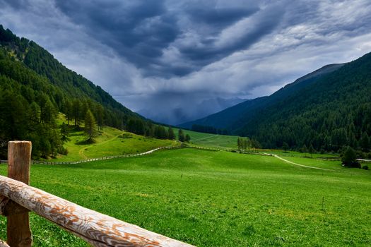 Beautiful green valley under cloudy skies in Schlinig, Trentino-Südtirol, Italy.