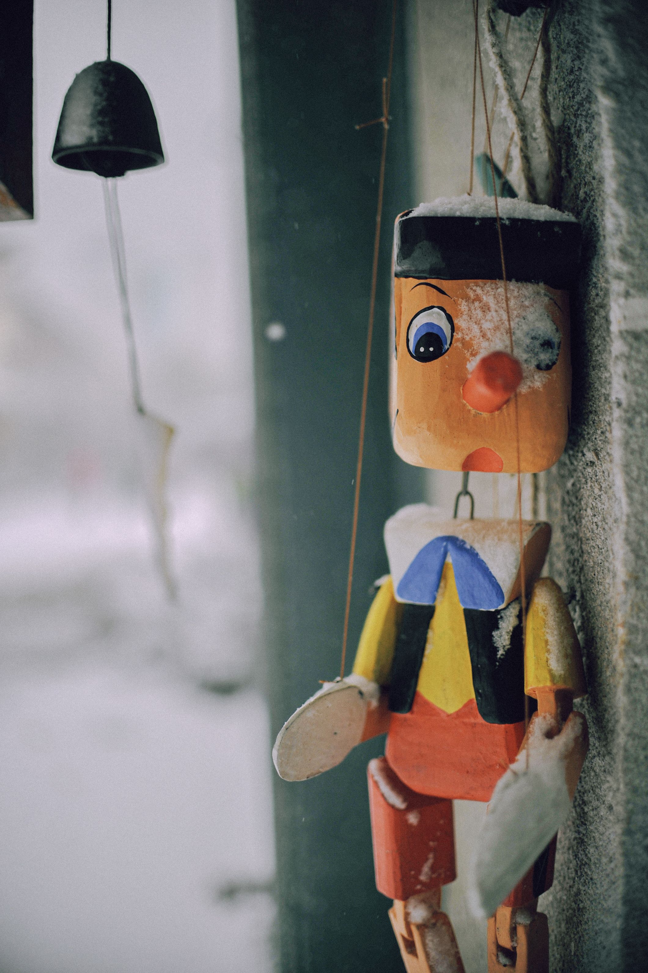 Vintage Wooden Puppet Covered in Snow · Free Stock Photo