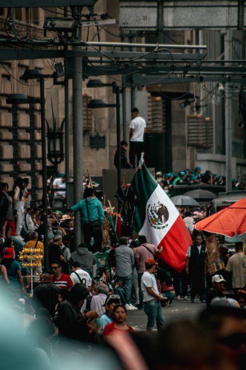 Free Vibrant scene of people celebrating in Mexico City, featuring the Mexican flag and urban atmosphere. Stock Photo