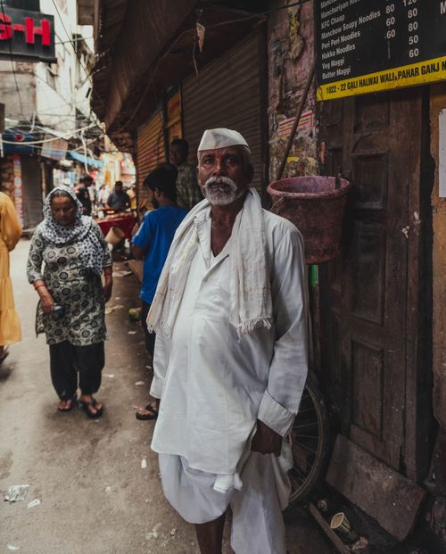 Free Local people in traditional attire walk through a bustling street in Paharganj, Delhi, India. Stock Photo