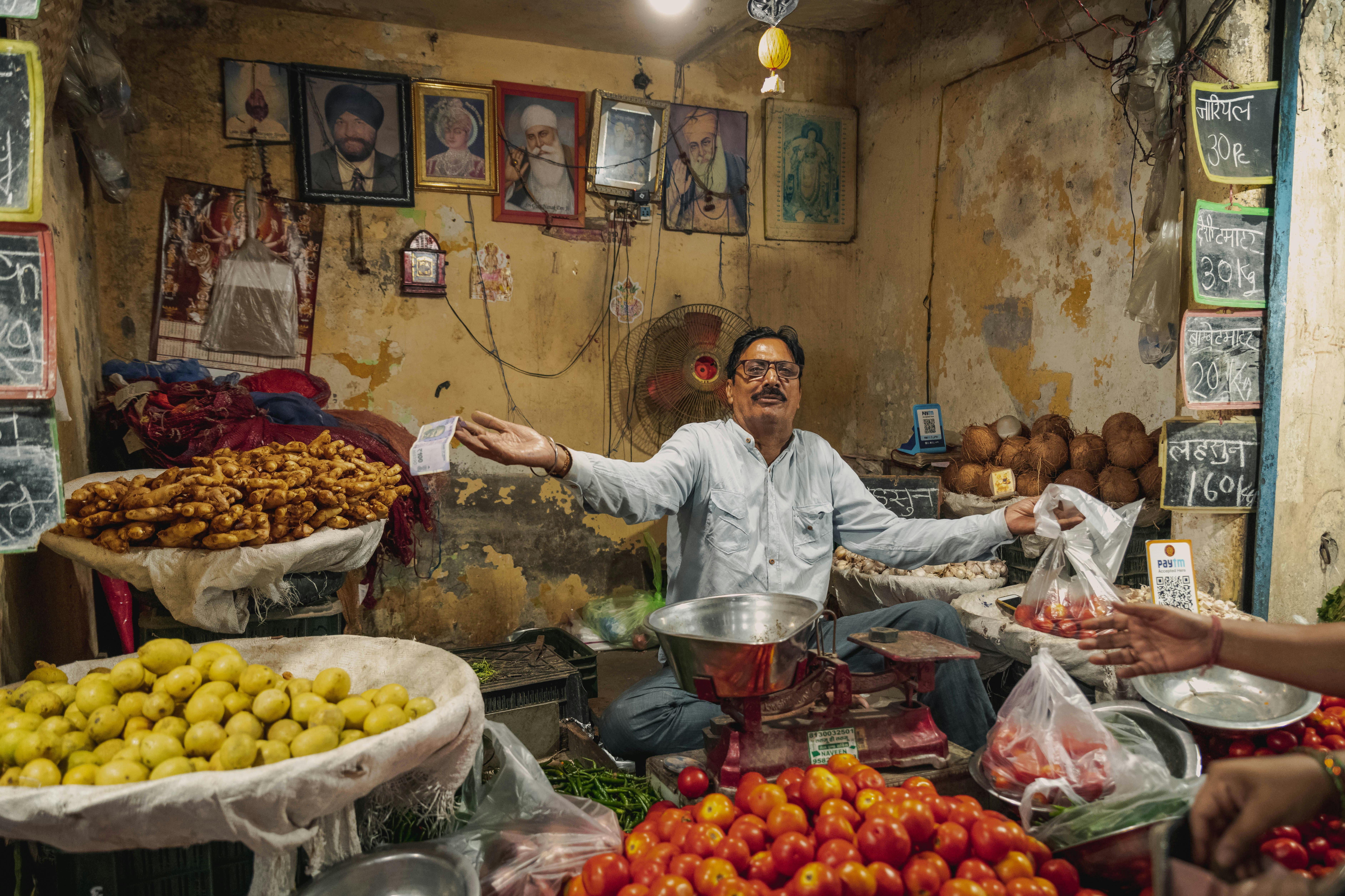 A vibrant scene of a vendor selling fresh produce in a bustling Delhi market.