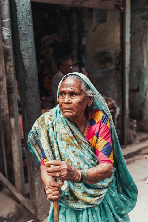 Free Portrait of an elderly Indian woman in colorful traditional dress outdoors in Delhi Stock Photo
