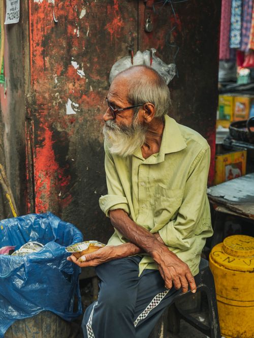 Free Portrait of an elderly man in a colorful market scene, Delhi, India. Stock Photo