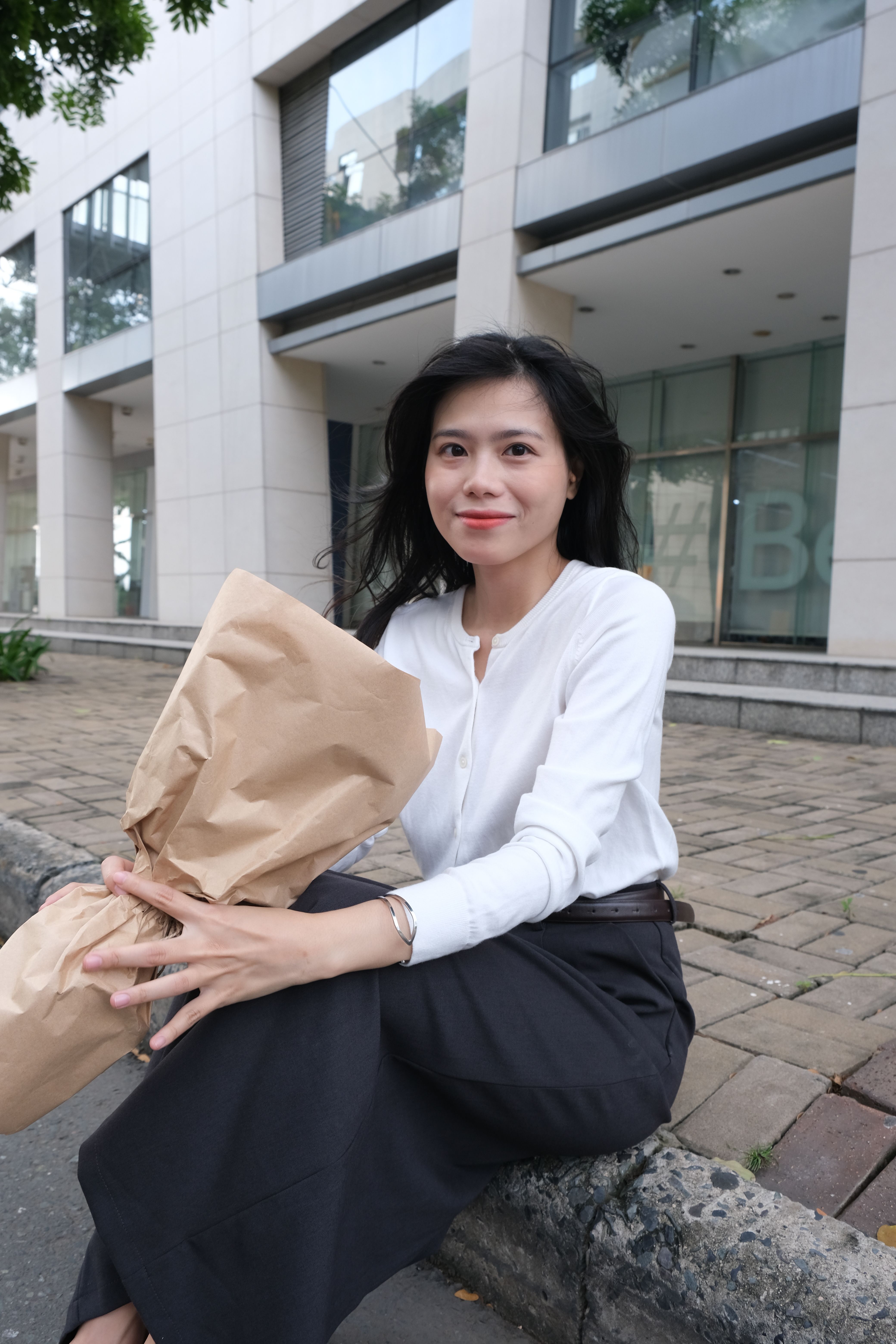 Smiling woman holding bouquet in Thành phố Hồ Chí Minh, Vietnam.