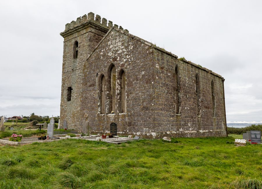Historic stone church in Wexford, Ireland, showcasing medieval architecture in a serene setting.