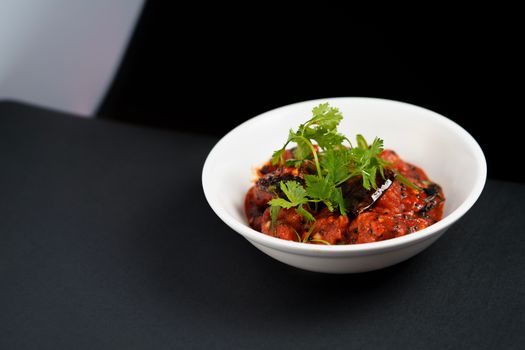 Savor the vibrant flavors of Hyderabadi eggplant curry, garnished with fresh coriander.