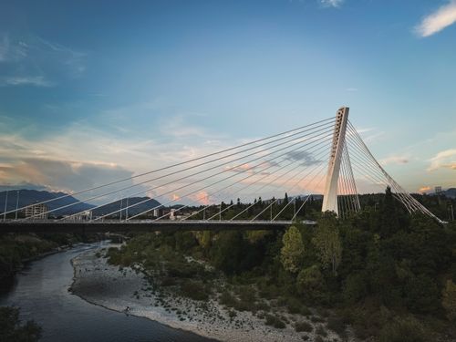 Free Stunning view of a cable-stayed bridge spanning over a river with scenic background. Stock Photo