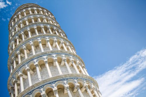 Free Iconic Leaning Tower of Pisa under a blue sky, a symbol of Italian architecture and history. Stock Photo