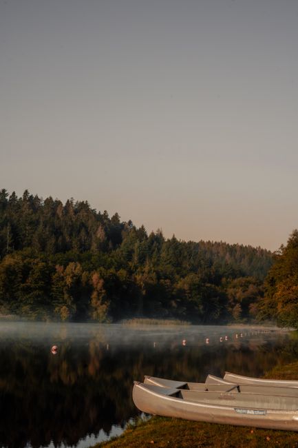 Canoe pulled up on a rocky shoreline beside calm lake water in the Boundary Waters