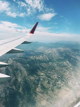 Scenic aerial view from airplane window showcasing mountainous terrain.