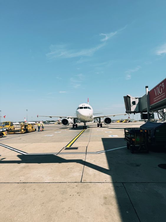 Commercial airplane parked at an airport terminal gate under a clear sky