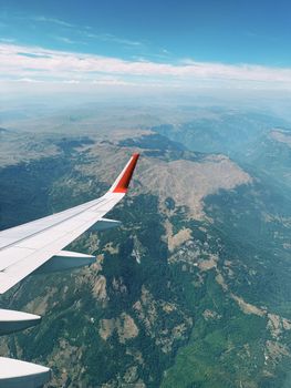 Stunning aerial view of vast mountain landscape from airplane window, showcasing natural beauty.