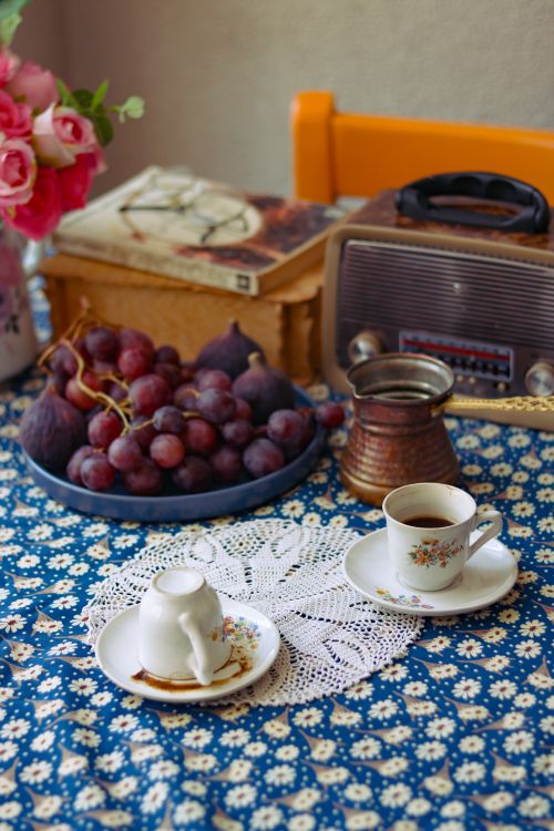Free Charming vintage tea scene with fruits, flowers, and retro radio. Stock Photo