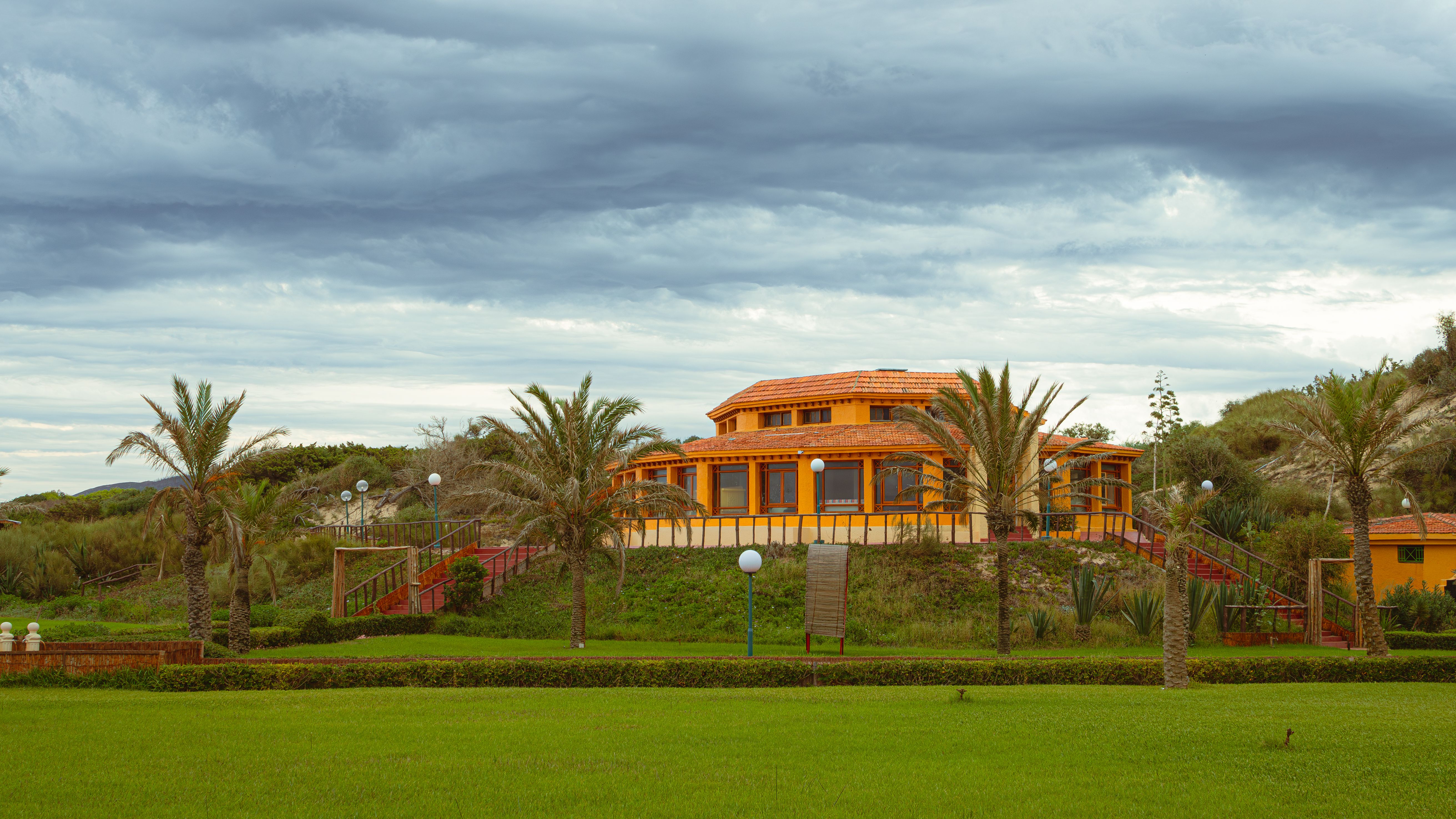 A vibrant house in Tabarka, Tunisia, under a dramatic cloudy sky. Perfect travel destination.